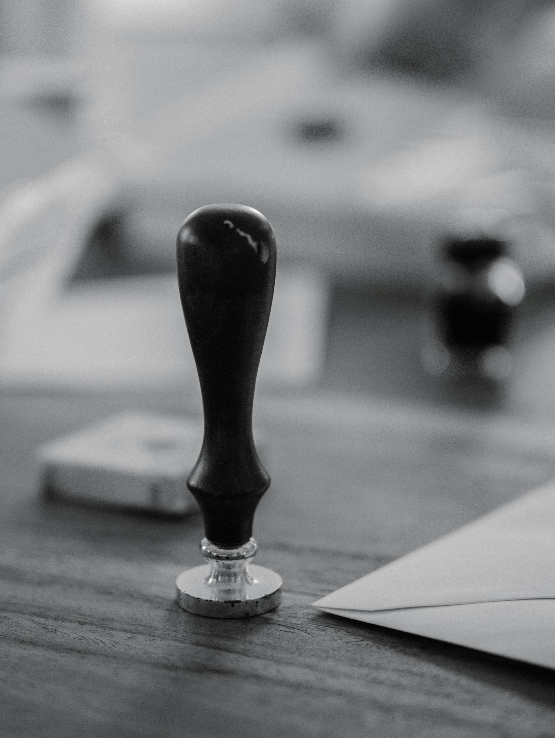 A wooden stamp sits on a wooden desk